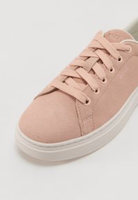 Sneaker in suede rosa con punta rotonda, tomaia testurizzata, chiusura con lacci e suola in gomma bianca. Presenta un discreto logo del marchio sul lato.