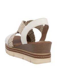 Sandale compensée avec un dessus tissé brun et crème texturé. Comprend des accents en cuir blanc et une semelle superposée et crantée pour plus de stabilité.
