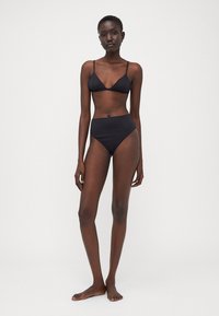 Black bikini set consisting of a triangular bralette top and high-waisted bottom, featuring a smooth texture and minimalistic design.
