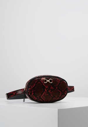 Bolso cinturón de forma ovalada con patrón de piel de serpiente en rojo y negro, detalle de cierre dorado y correa ajustable, colocado sobre una superficie blanca.