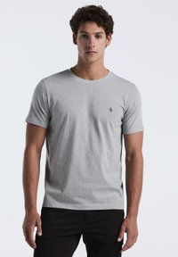 Grijze T-shirt met korte mouwen, gemaakt van zachte stof, met een ronde halslijn en een klein, donker logo op de linkerkant van de borst.