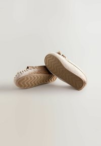 Chaussures slip-on marron et crème en tissu texturé, avec un motif à pois et des semelles en caoutchouc dotées d'un design de semelle en zigzag.