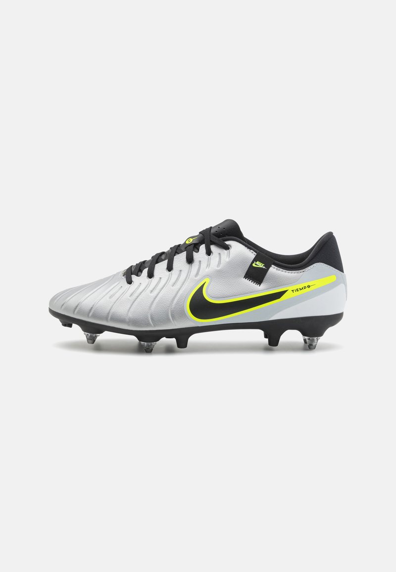 Nike Tiempo fodboldstøvle i sølv med sorte accenter. Har en tekstureret overdel, gule detaljer og gennemsigtige studs for traction.