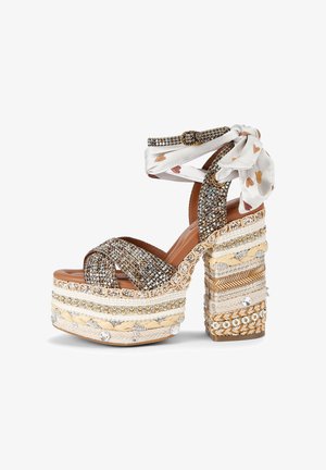 Platform high heel sandal with glitter straps, braided and beaded beige sole, and ankle wrap scarf with heart pattern.