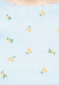 Ανοιχτό μπλε ριμπ ύφασμα με μικρές τυπωμένες συστάδες κίτρινων λεμονιών και πράσινα φύλλα, παρουσιάζοντας μια κοντινή όψη του μοτίβου και της υφής.