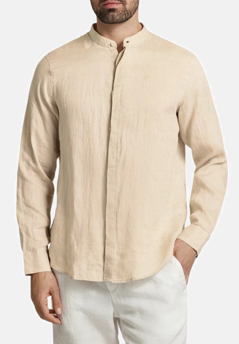 Camicia in lino beige con colletto alla cinese, maniche lunghe, patta anteriore e vestibilità comoda. Texture morbida; aspetto liscio e leggermente stropicciato.