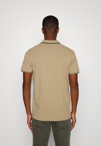 Polo shirt khaki a maniche corte, con rifiniture verdi al colletto e alle maniche, tessuto leggero e vestibilità rilassata.