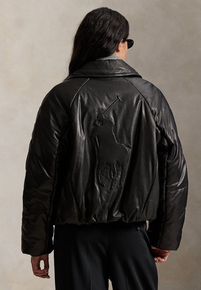 Geacă puffer neagră din piele, cu croială scurtă, prezentând un logo brodat cu cal pe spate și o textură lucioasă.