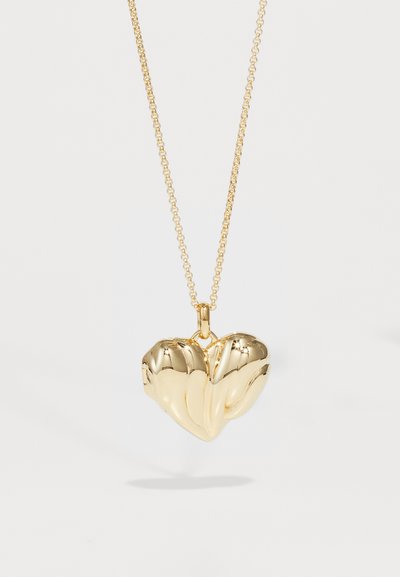 Ciondolo a forma di cuore in oro con una finitura liscia e strutturata, dotato di una chiusura removibile e appeso a una delicata catena dorata.