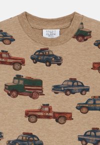 Καφέ πουκάμισο με εκτυπωμένα vintage αυτοκίνητα της αστυνομίας και οχημάτων έκτακτης ανάγκης σε μπλε, πράσινο και κόκκινο, διάσπαρτα σε όλο το ύφασμα.