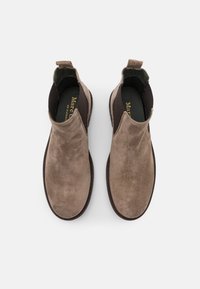 Bottes cheville en daim marron avec une texture lisse, des panneaux latéraux élastiques et une boucle. Elles présentent une semelle et une semelle intérieure contrastantes de couleur foncée.