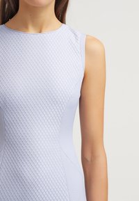 Jasnofioletowa sukienka bez rękawów z teksturowanym heksagonalnym wzorem i gładkim panelem bocznym. Miękki, elastyczny materiał.