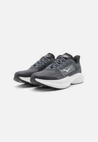 Chaussures de course Hoka avec une tige en mesh noir et gris, une semelle intermédiaire blanche, une semelle extérieure texturée et le logo signature sur le côté.