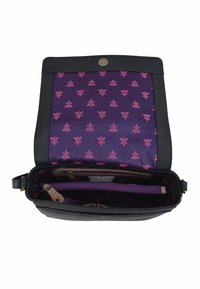 Schwarze Lederhandtasche mit einem Magnetverschluss, ausgestattet mit einem lila floral gemusterten Innenfutter und einer Reißverschlusstasche zur Organisation.