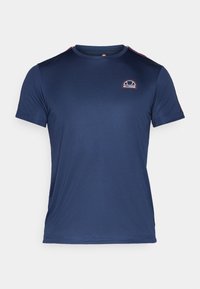 Námořnická modrá sportovní tričko vyrobené z hladkého, lehkého materiálu. Obsahuje malé logo na hrudníku a červené akcenty na ramenou.
