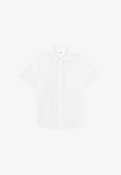 Chemise blanche à manches courtes boutonnée avec col et poche poitrine, étalée à plat sur un fond blanc.