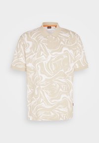 Polo manches courtes beige et blanc marbré avec patte à deux boutons et col rabattu présenté sur fond uni.