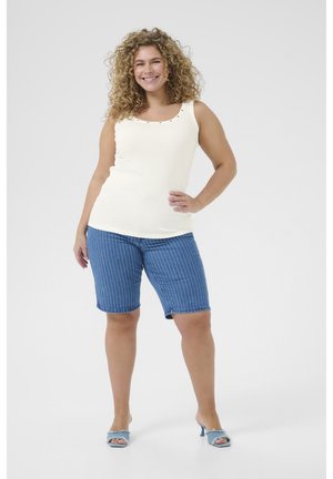 Ivoor geribbeld tanktop met decoratieve schouderaccenten, gecombineerd met blauwe gestreepte bermudashorts en lichtblauwe open-toe hakken.