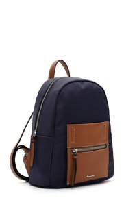 Compact navy backpack with brown leather front pocket and silver zipper, featuring adjustable brown straps and top handle.