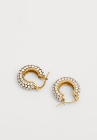 Gullringer i gull prydet med klare rhinestones, med en glatt tekstur og en elegant, buet design med hengslet lås.
