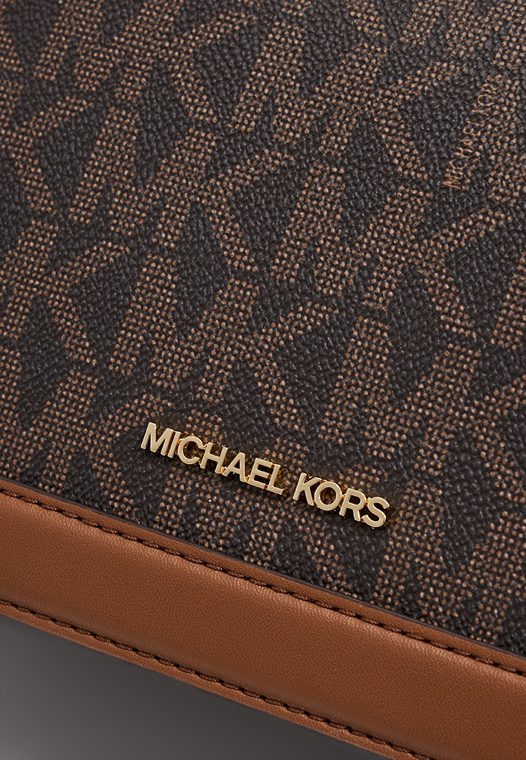 Braune und schwarze strukturierten Geldbörse mit geometrischem Muster, einem goldenen "Michael Kors"-Logo und einem glatten braunen Lederakzent.