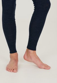 Marinblå träningsleggings med en �åtsittande design, mjuk textur och ankellång längd, med en ribbad manschett vid nederkanten.