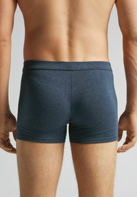 Pánské tmavě modré boxerky vyrobené z měkké, elastické tkaniny. Mají střih s těsným provedením, elastický pas a žádné viditelné vzory.