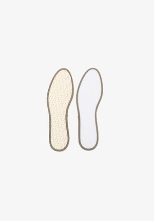 Deux semelles de chaussures côte à côte, l'une beige avec de petites perforations et l'autre blanche unie, toutes deux avec des bords marron cousus.