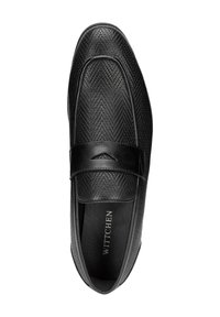 Mocasines negros con un patrón texturizado y tejido, que presentan una banda de cuero suave en el empeine y un logo sutil en el interior.