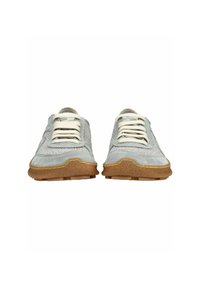 Paar grijze suède casual sneakers met witte veters en getextureerde bruine rubberen zolen, gezien vanaf de voorkant.