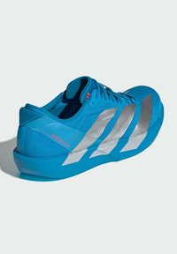 Modré sportovní boty s texturovaným svrškem a stříbrnými pruhy, zaoblenou špičkou a lehkou podešví pro výkon.