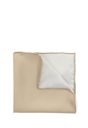 Beżowy koc o gładkiej teksturze, z białym spodem. Krawędzie są obszyte delikatną lamówką, z widocznym zagiętym rogiem.