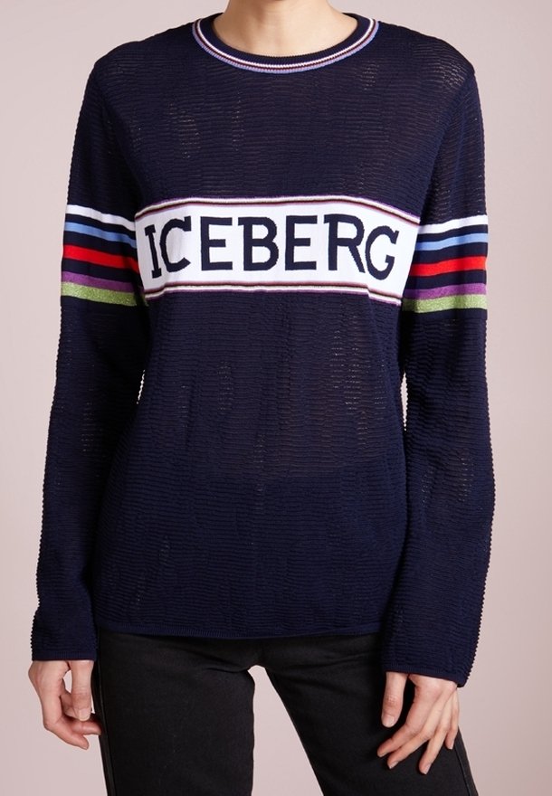Granatowy sweter dziany z poziomymi paskami w kolorach czerwonym, białym i zielonym. Z przodu na piersi białe logo „ICEBERG”.