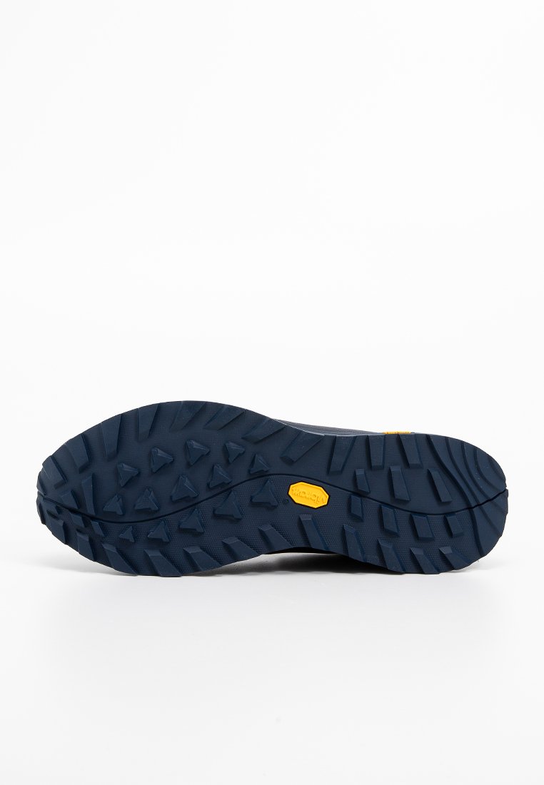 Podeszwa Vibram buta trekkingowego, z fakturowaną, ciemnoniebieską gumową powierzchnią z wielokierunkowymi kołkami i żółtym detalem z logo.