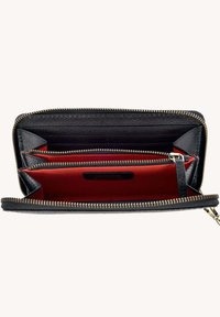 Portefeuille en cuir noir zippé, ouvert pour montrer un intérieur en tissu rouge avec plusieurs emplacements pour cartes et un compartiment à pièces zippé.