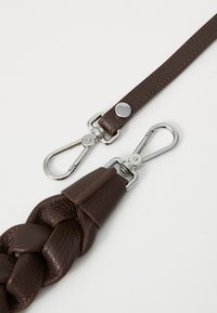 Cintura intrecciata in pelle marrone con hardware in metallo argentato, dotata di due ganci a scatto e un pezzo decorativo in pelle per l'attacco.