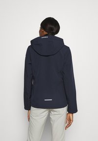 Granatowa wodoodporna kurtka z kapturem, z białym logo na plecach oraz odblaskowym pasem u dołu dla lepszej widoczności. Gładka faktura.