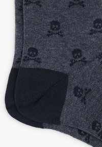 Calcetines grises de tela de punto, con un patrón de calaveras y huesos cruzados oscuros. Secciones de talón y puntera azul marino con puños acanalados.