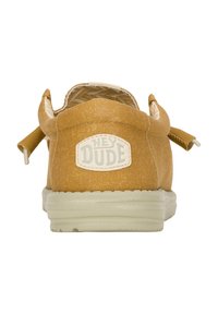 Scarpa slip-on in tela marrone con finitura testurizzata, dotata di suola in gomma bianca e un'etichetta con la scritta "HEY DUDE" sul retro.