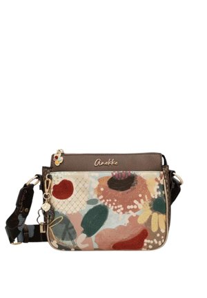 Piccola borsa a tracolla con parte superiore marrone, motivo floreale multicolore, tracolla regolabile e ciondolo a forma di chiave dorato su sfondo bianco.