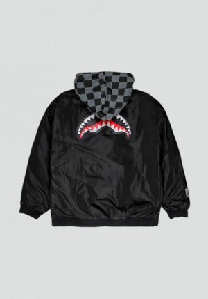 Giacca nera con finitura lucida, caratterizzata da una grafica di squalo rossa e bianca sul retro, un cappuccio a quadri grigi e polsini a coste.