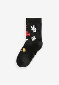 Svart socka med färgglada mönster, inklusive röda hjärtan, fredstecken och gula stjärnor, med en mjuk textur och elastisk mudd.