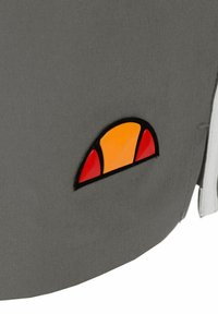 Grijze stoffen jas met een multikleurige patch met gele, oranje en rode secties in de vorm van een halve zon.