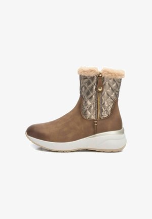 Botas tobilleras marrones con parte superior sintética suave, cuello metálico acolchado, ribete de pelo sintético y suela blanca y beige. Detalle de cremallera lateral.