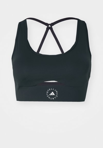 Μαύρο αθλητικό σουτιέν με σχήμα κοπής στον λαιμό, διασταυρούμενες τιράντες στο πίσω μέρος και υφή στην επιφάνεια. Διαθέτει κυκλικό λογότυπο μπροστά.