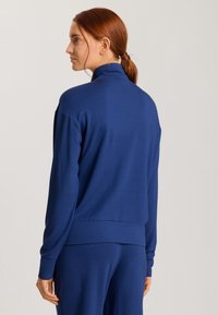 Sudadera de cuello alto en azul marino, de manga larga y con ribete en el dobladillo. Tejido liso con una silueta ajustada.