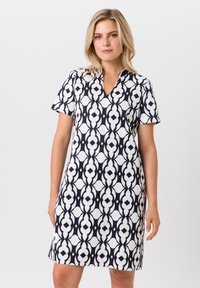 Korte mouw jurk met een zwart-wit geometrisch patroon, een v-hals, zachte stof en een getailleerde pasvorm.