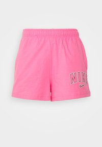 Růžové sportovní šortky z bavlny s elastickým pasem a bočními kapsami. Na přední straně je vytištěné černé logo "NIKE".