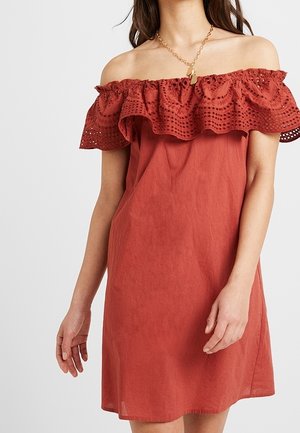 Vestido off-the-shoulder en un color óxido con un escote rizado y bordeado de encaje. Fabricado con un material ligero, tiene un corte holgado.
