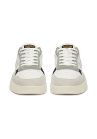 Baltas zemā profila kedas ar pelēkiem zamšādas akcentiem, perforētu purngala daļu un melnu sānu logotipu. Aprīkotas ar baltām auklām un bēša krāsas zoli. Zīmola etiķete uz mēlītes.